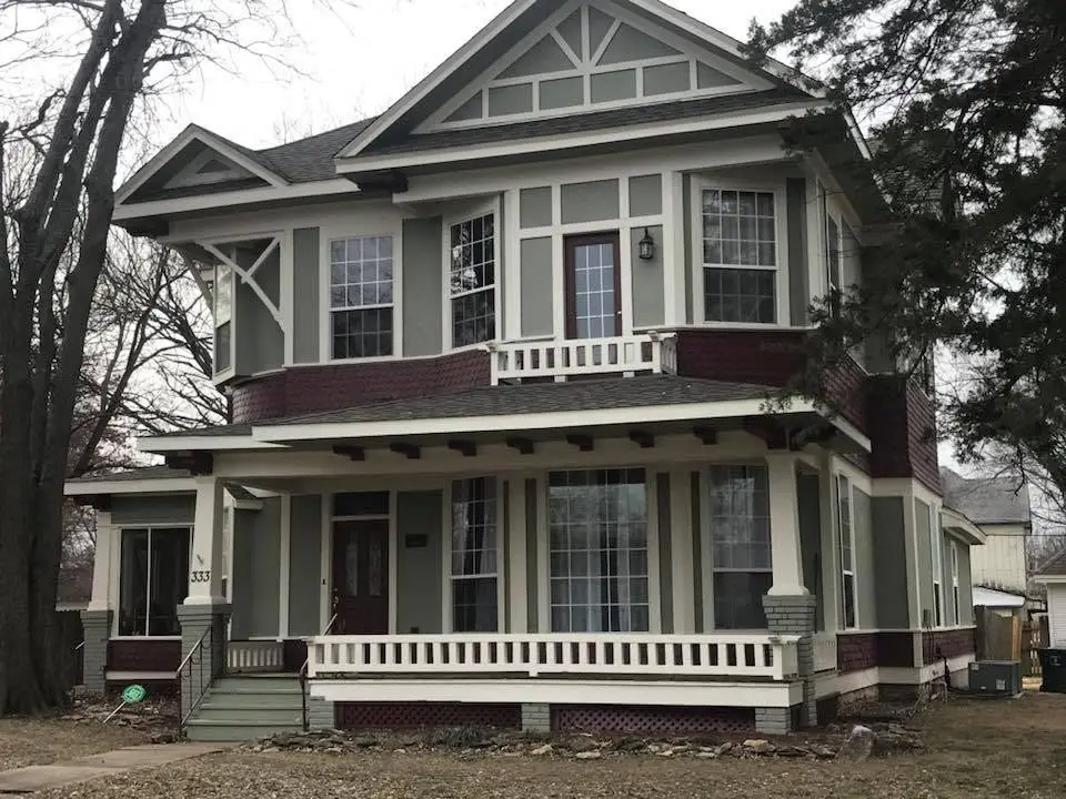 Historic two-story Claremore home with restored lap siding, trim, and a new roof by C&A Roofing & Construction